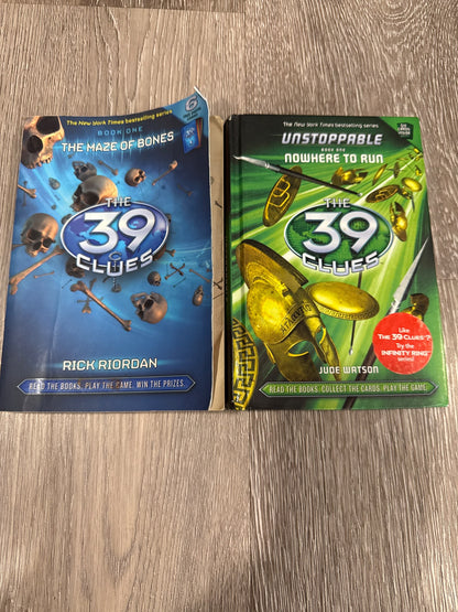 Two of the famous 39 Clues books The Maze of Bones and Nowhere to Run