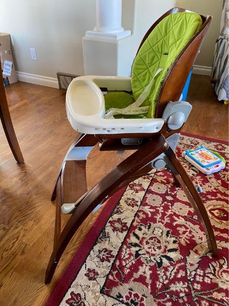 Brown highchair with removable lime green padding and tray