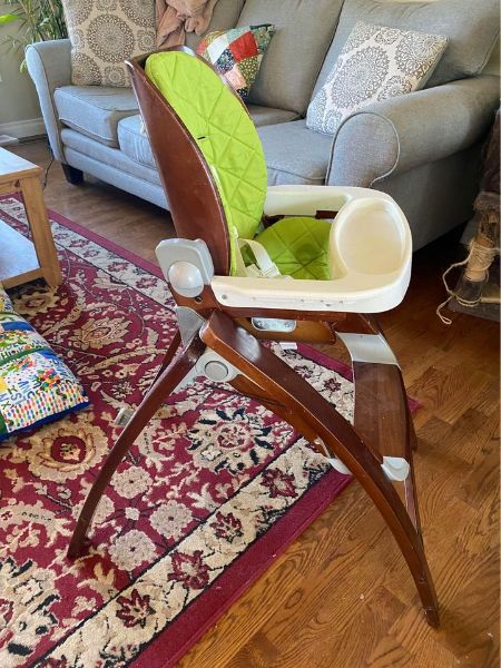 Brown highchair with removable lime green padding and tray