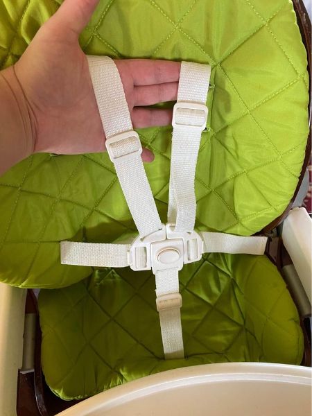 Brown highchair with removable lime green padding and tray