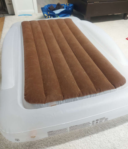 Inflatable travel bed with safety bumpers