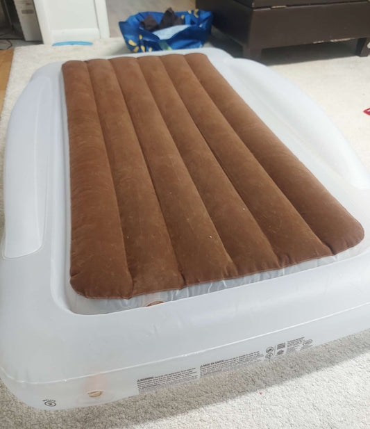 Inflatable travel bed with safety bumpers